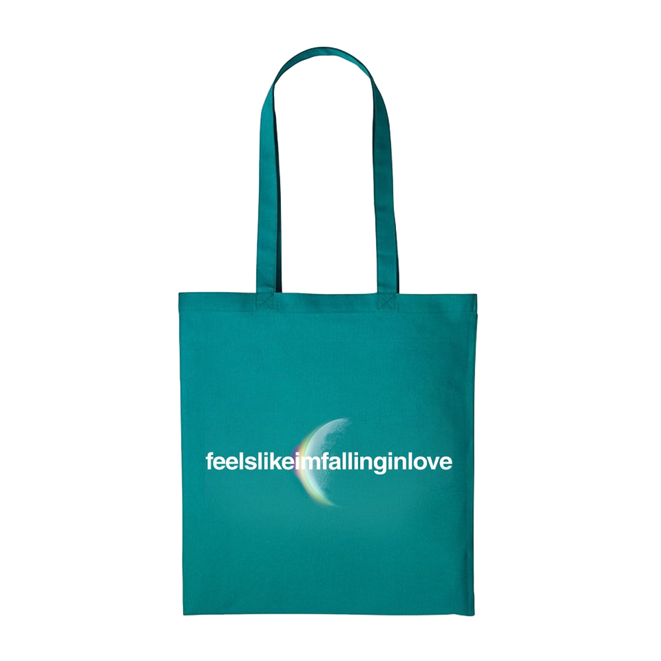 Front: feelslikeimfallinginlove written in white. A crescent moon glows from behind with an eclipsing light dispersion: from the cotton cloud-like white of the moon, to a light greenish hue, to soft pale yellow, to purple, giving it a dreamy, ethereal quality. The fabric is teal, a blueish shade of green.