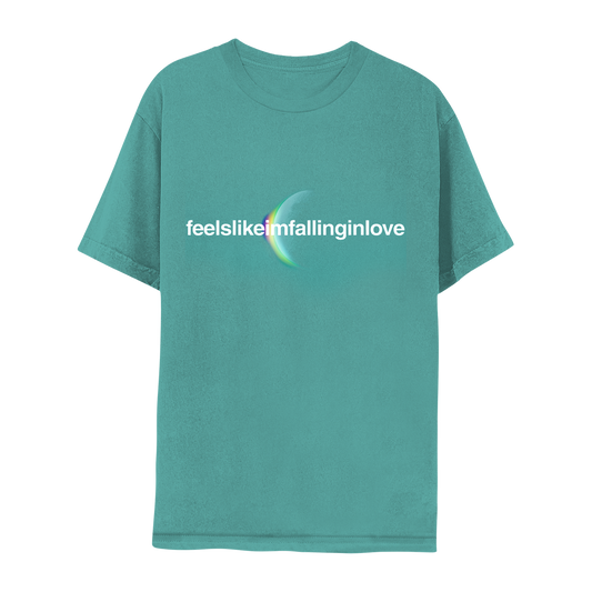Front: feelslikeimfallinginlove written in white. A crescent moon glows from behind with an eclipsing light dispersion: from the cotton cloud-like white of the moon, to a light greenish hue, to soft pale yellow, to purple, giving it a dreamy, ethereal quality. The fabric is teal, a blueish shade of green.