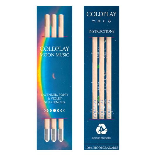 Package view from 2 sides. Front: a🌘&a large arced rainbow light dispersion to the right. Colors flow from red to orange, yellow, green, light&dark blue, fading into deep blue background. Text reads: COLDPLAY, MOON MUSIC, LAVENDER, POPPY&VIOLET SEED PENCILS. There’s a 7-phase moon cycle from🌒to🌕in the center, back to🌘 The back of the package reads: COLDPLAY, with a 🤍♾️a circle&Chris’s rainbow doodle. Text, moons&symbols are white. Instructions,♻️RECYCLED PAPER, 100%BIODEGRADABLE, package has 3 pencils